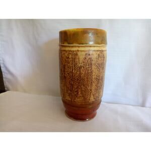 Vintage heavy ceramic vase with leaf pattern running vertically around it.